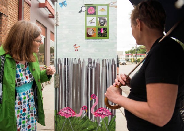 Members of the Prospect Park Association take a tour of utility boxes in the area that have been wrapped in art by local artists. The project was completed in an effort to stop graffiti and bring beauty to the neighborhood. - photo courtesy MN Daily